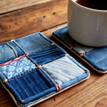 **

Upcycled denim coasters on a rustic wooden table. The coasters are patchwork style, made from various shades of blue denim. A steaming mug sits on one coaster. Soft, natural light. Focus on texture and detail of the denim.

**